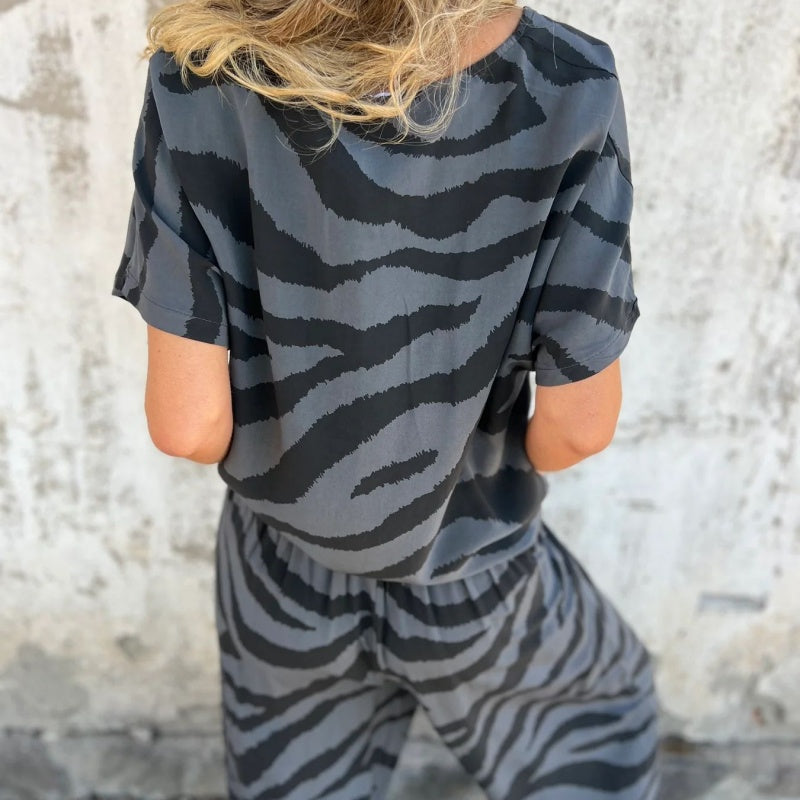 👗🦓 Zebramintás modern szett – Elöl megkötős felső, széles szárú nadrág, lélegző poliészter-viszkóz keverék! ✨💃